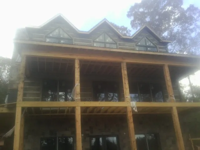Dormers and porch framing on a large log home under construction — Roof Coating work by our crew in Lake Junaluska