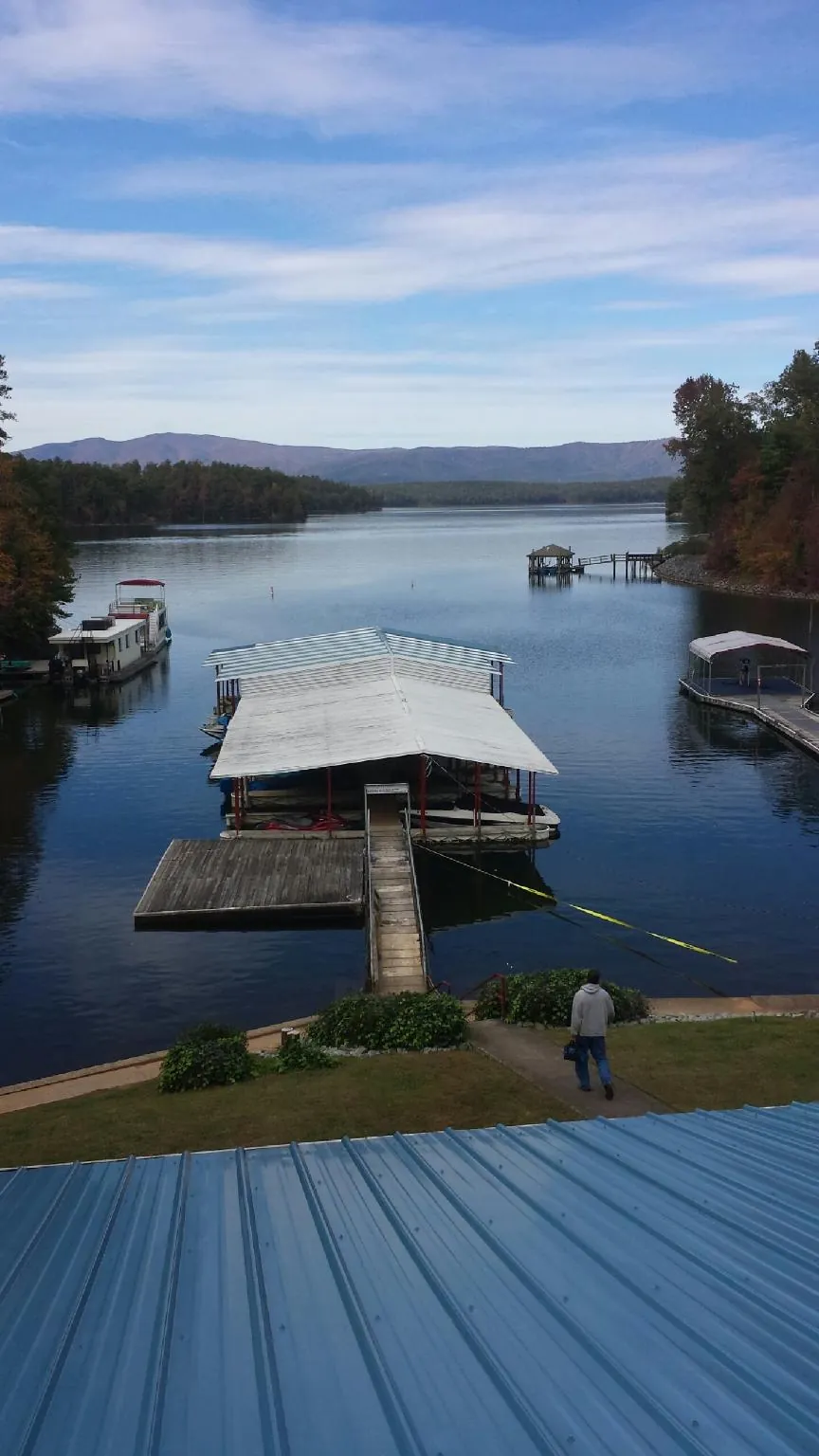 View across a lake from a newly installed blue metal roof in Lake Junaluska