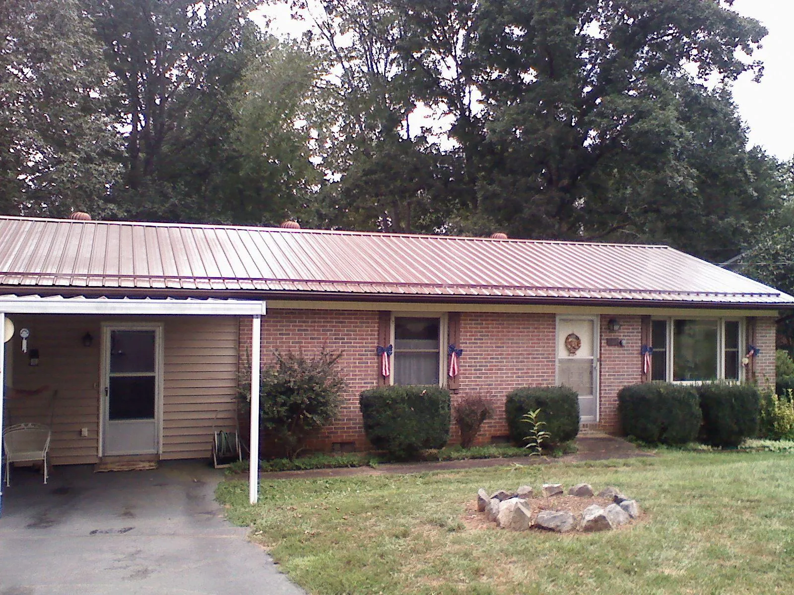 Bronze metal roof and carport on a brick ranch home — Roof Repair work by our crew in Lake Junaluska